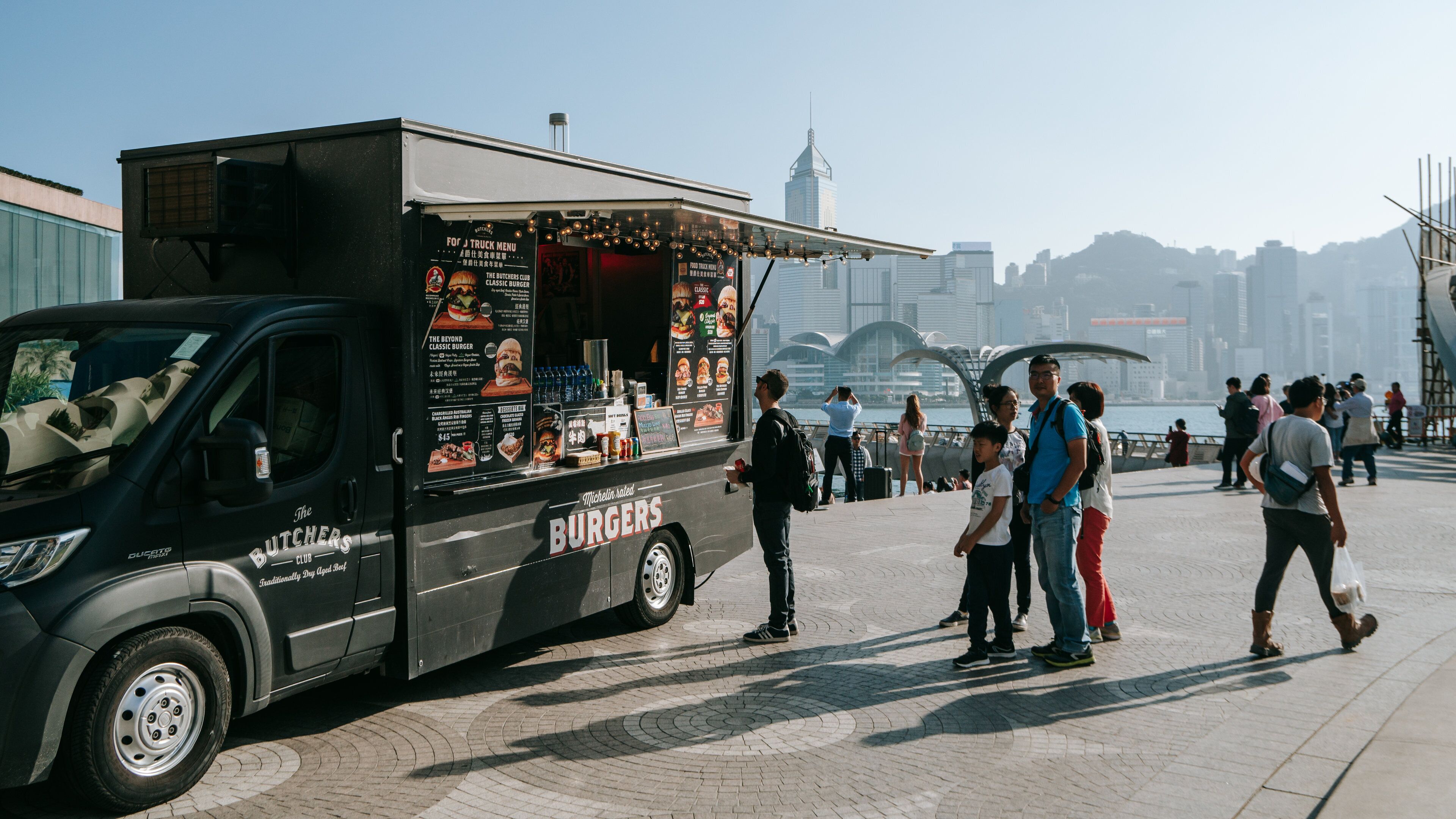 Tsim Sha Tsui Promenade featuring markets as well as a small group of people