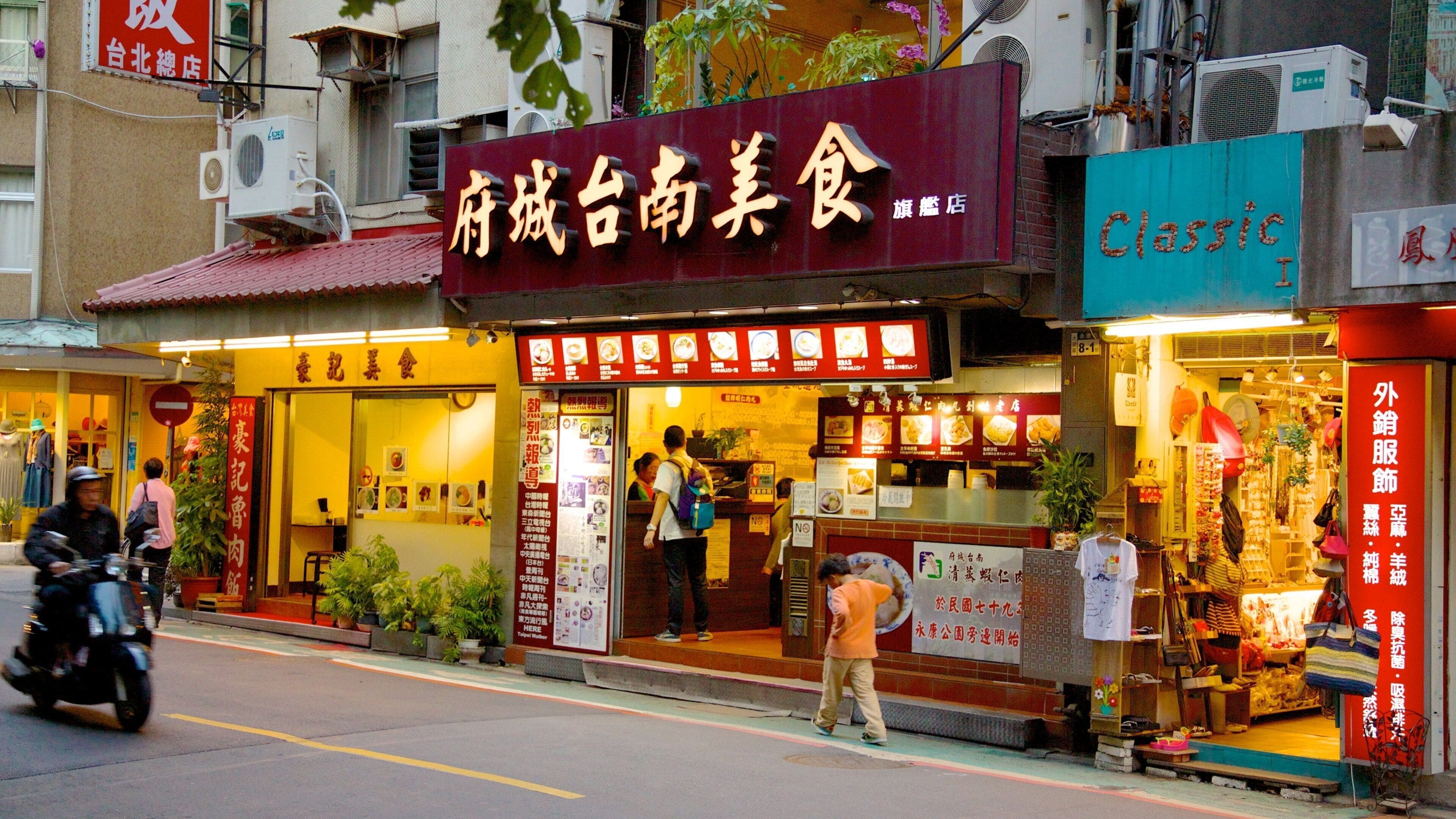 Una calle con un restaurante llamado "Shengcheng Nanjiaochao" y una tienda llamada "Classic I".