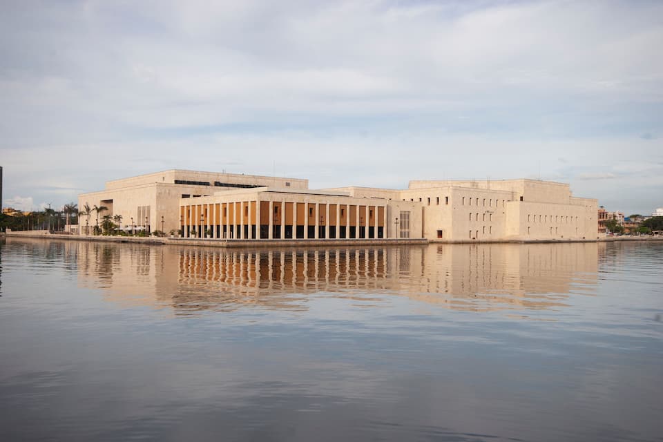 A large, modern building with a reflective pool in front.
