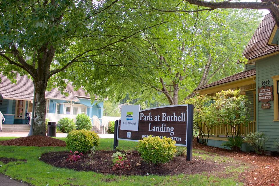 Placa do estacionamento Park at Bothell Landing, com um edifício histórico ao fundo.