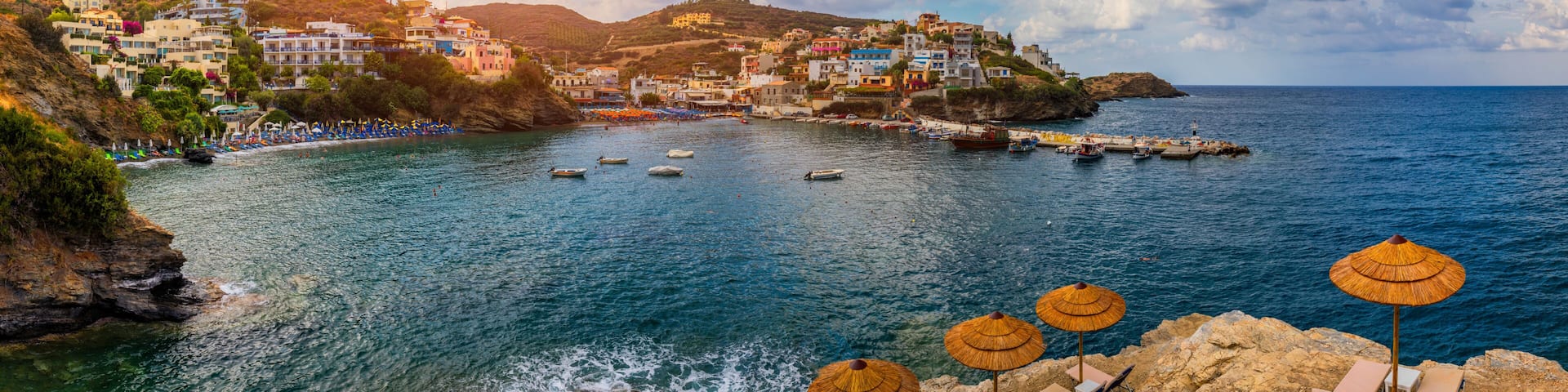 Panorama of Harbour with vessels, boats, beach and lighthouse in Bali at sunrise, Rethymno, Crete, Greece. Famous summer resort in Bali village, near Rethimno, Crete, Greece.
