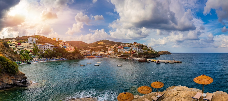 Panorama of Harbour with vessels, boats, beach and lighthouse in Bali at sunrise, Rethymno, Crete, Greece. Famous summer resort in Bali village, near Rethimno, Crete, Greece.