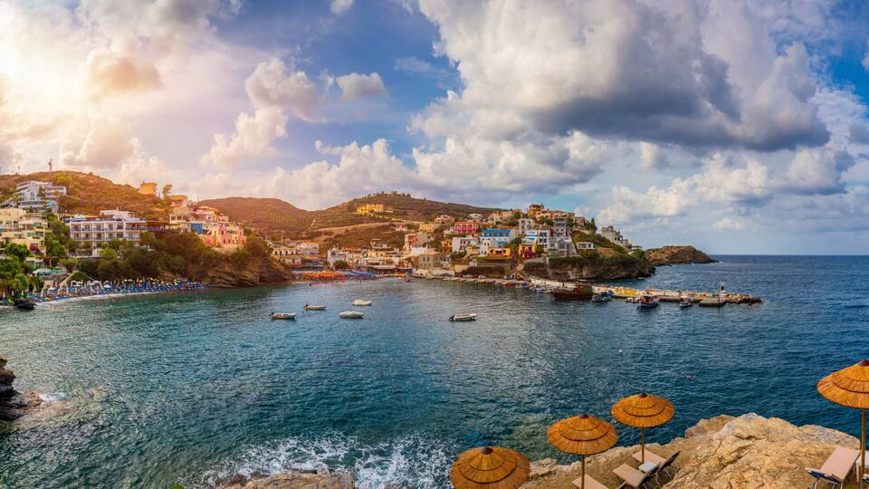 Panorama of Harbour with vessels, boats, beach and lighthouse in Bali at sunrise, Rethymno, Crete, Greece. Famous summer resort in Bali village, near Rethimno, Crete, Greece.