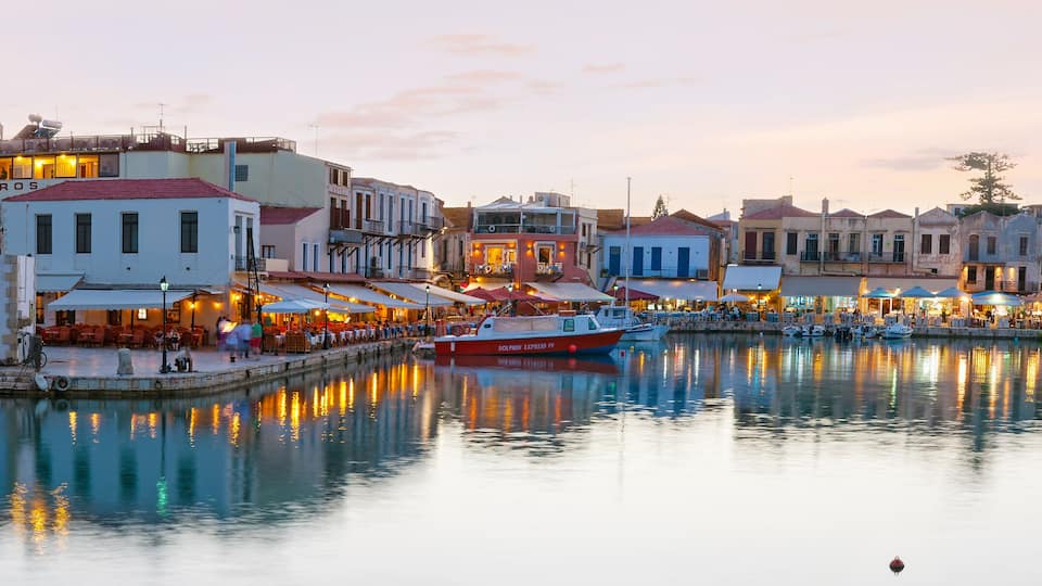 A waterfront town with buildings, a dock, and boats.