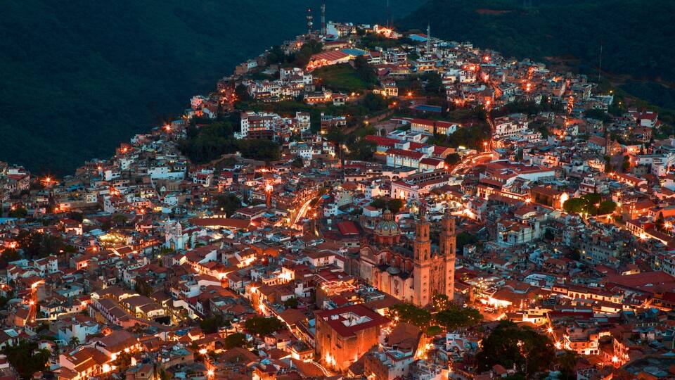 Santa Prisca Cathedral showing night scenes and a city