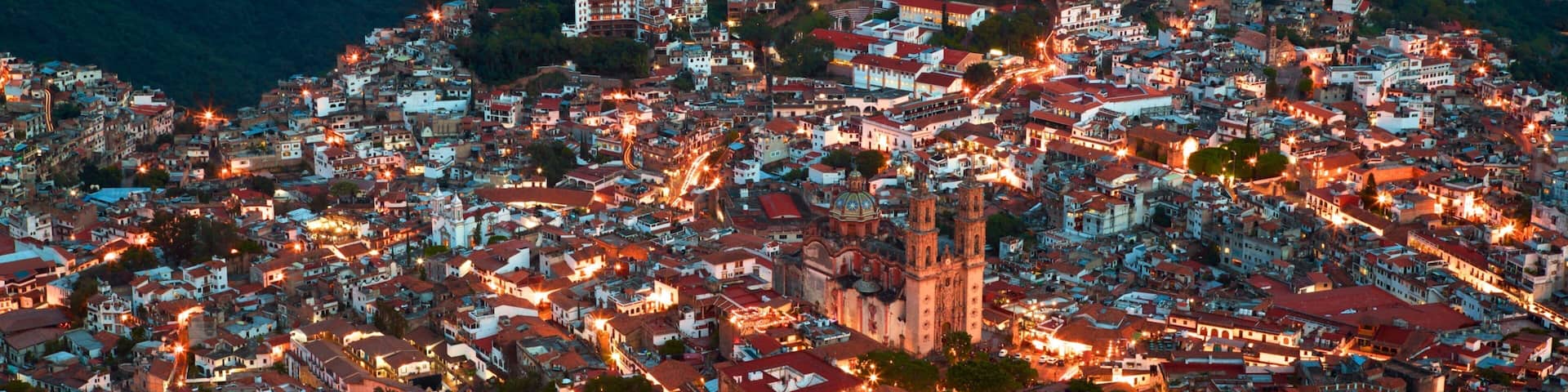 Santa Prisca Cathedral which includes night scenes and a city