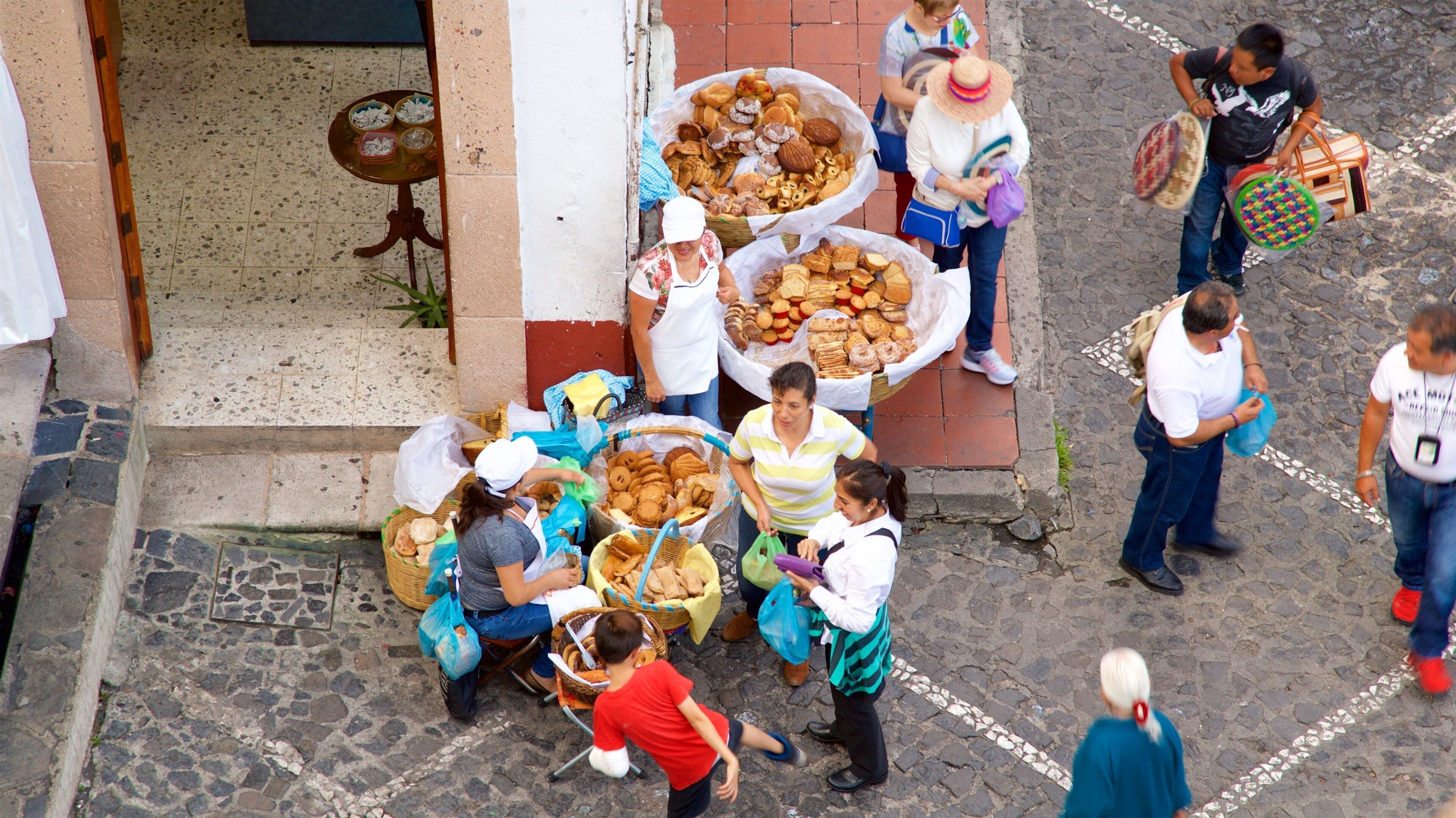 Un mercado callejero con diversos productos alimenticios exhibidos en cestas y mesas.