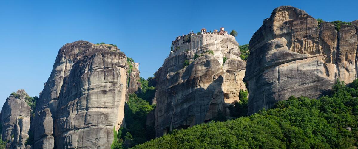 A rocky mountain with a monastery on top.
