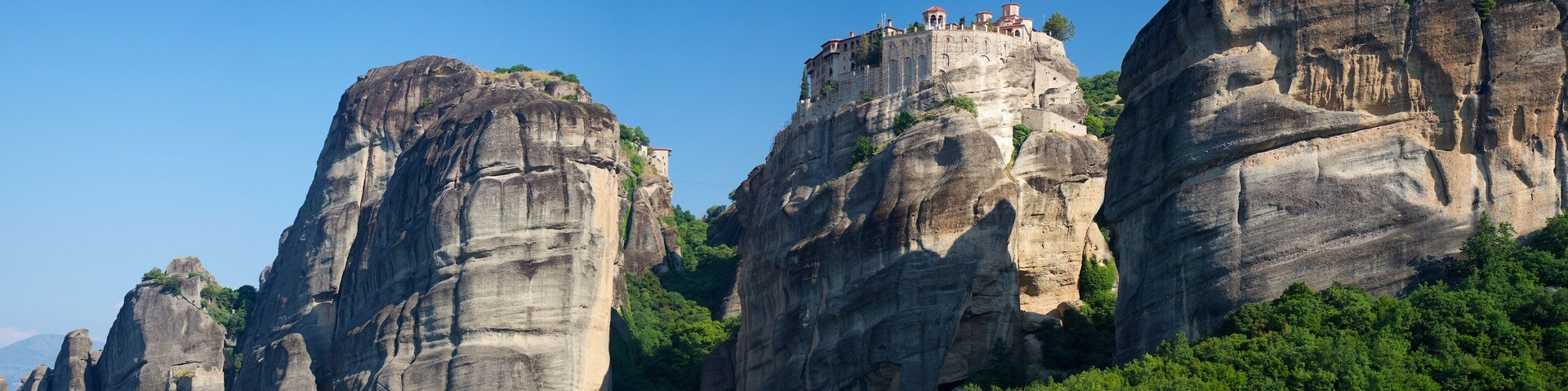 A rocky mountain with a monastery on top.