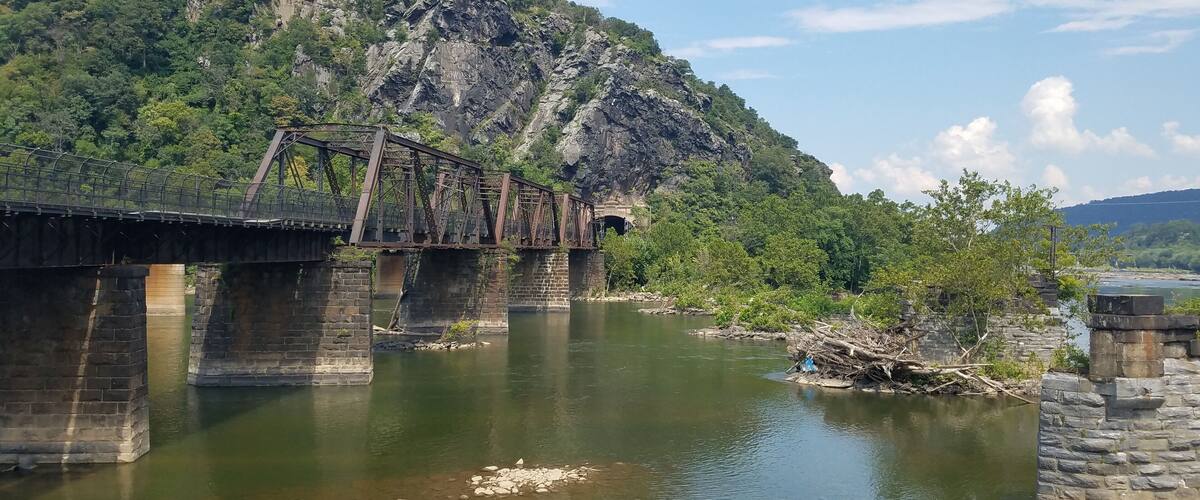 A river with a bridge and a mountain in the background.