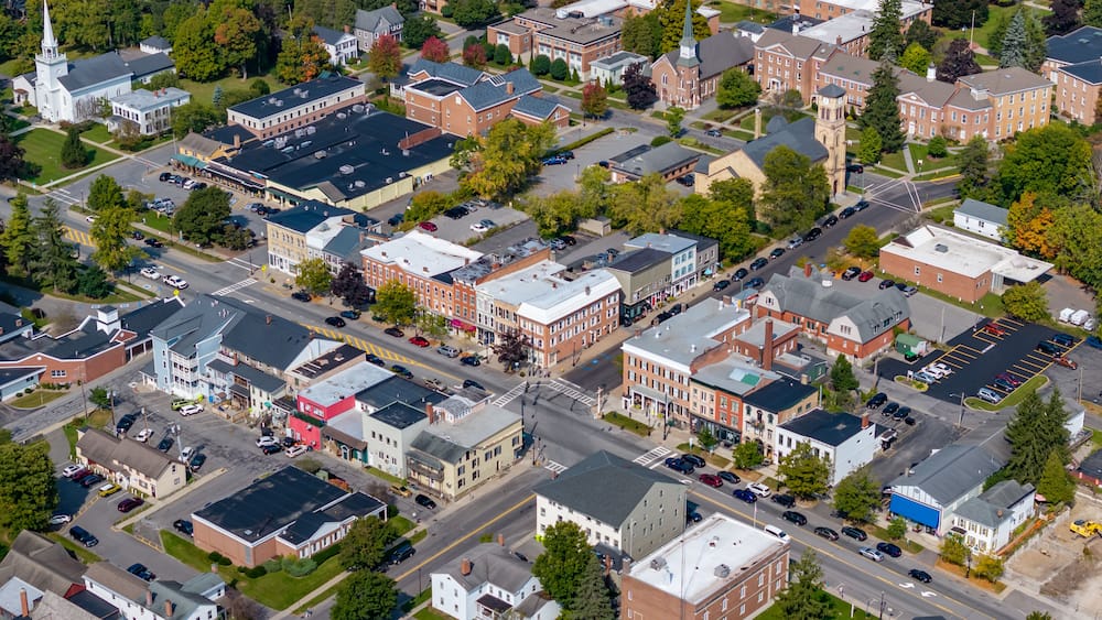 An aerial view of a town with various buildings, streets, and a church with a steeple.