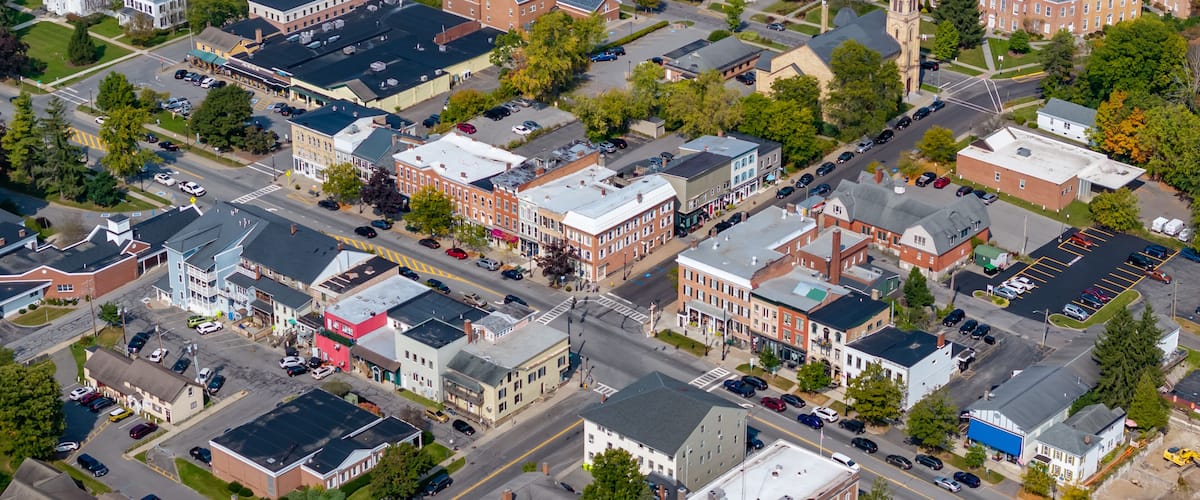 An aerial view of a town with various buildings, streets, and a church with a steeple.
