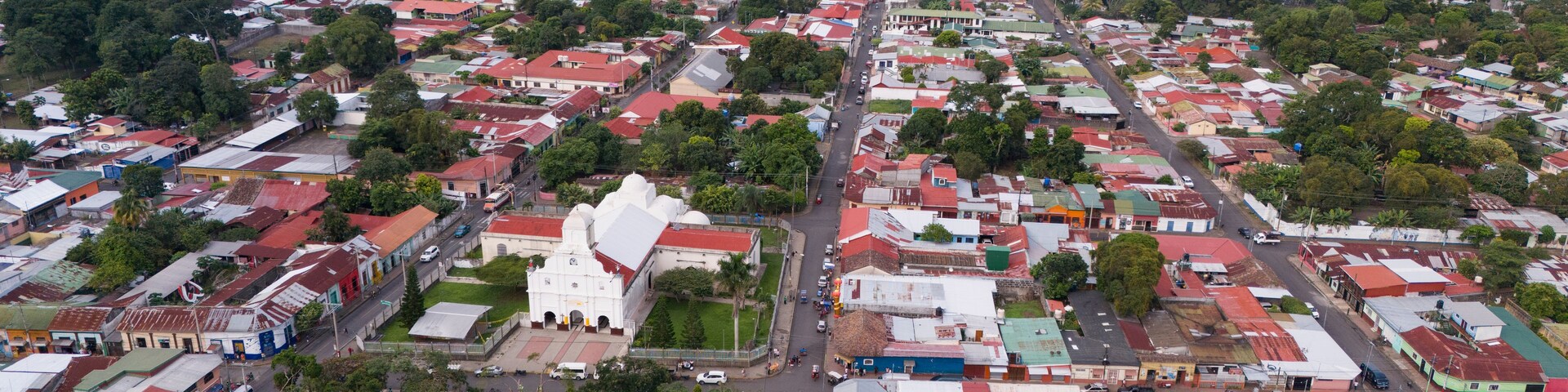 Un área urbana densamente poblada con una iglesia blanca destacada y una variedad de edificios de colores.