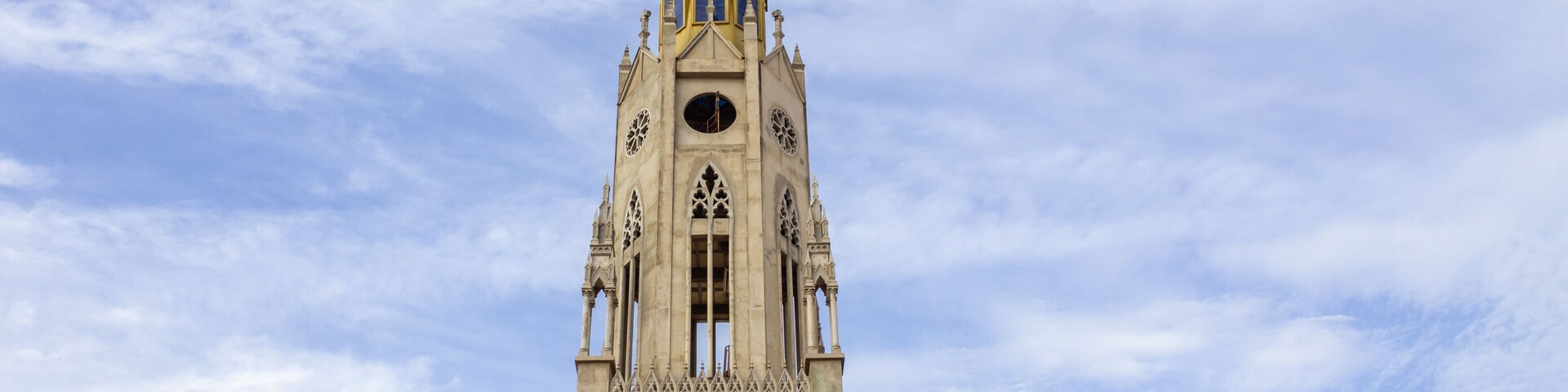 A tall, ornate church with a spire and clock tower.