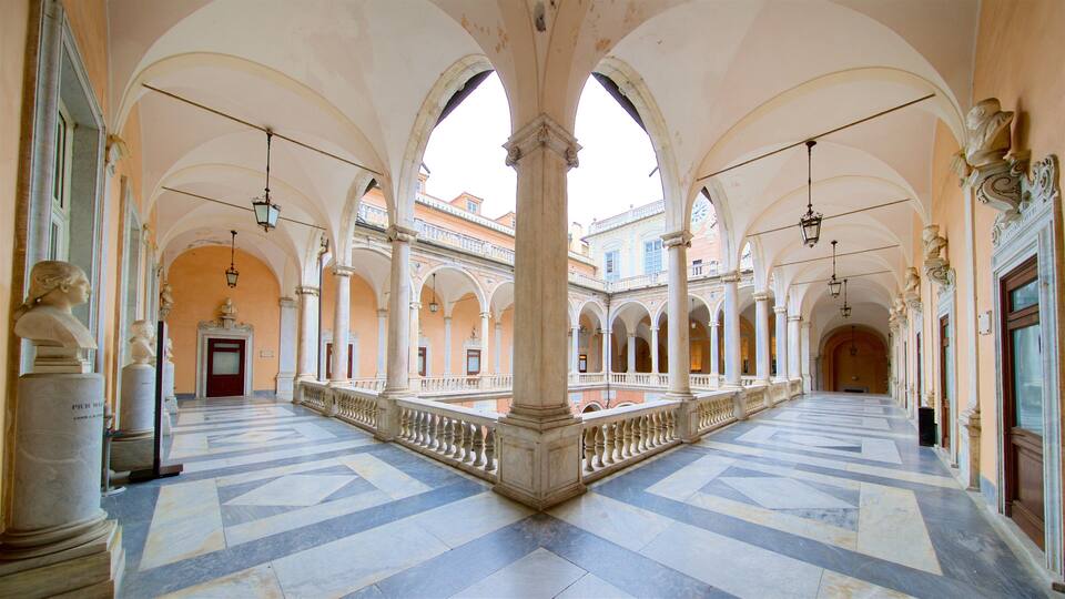 A spacious courtyard with arches, columns, and statues.
