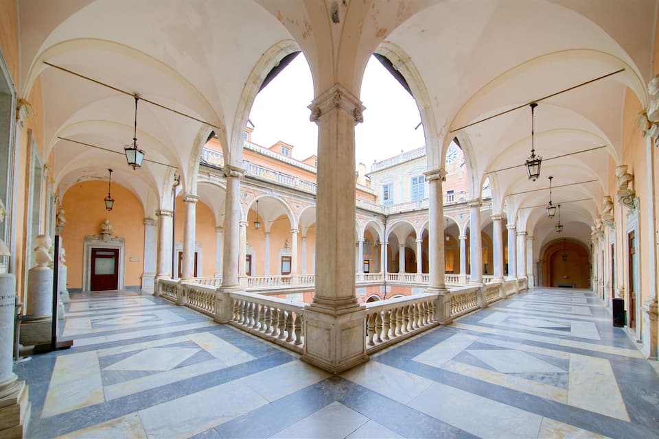 A spacious courtyard with arches, columns, and statues.