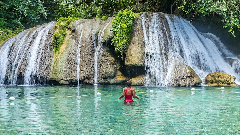 Ein Wasserfall stürzt über eine Felsformation in ein klares Becken.