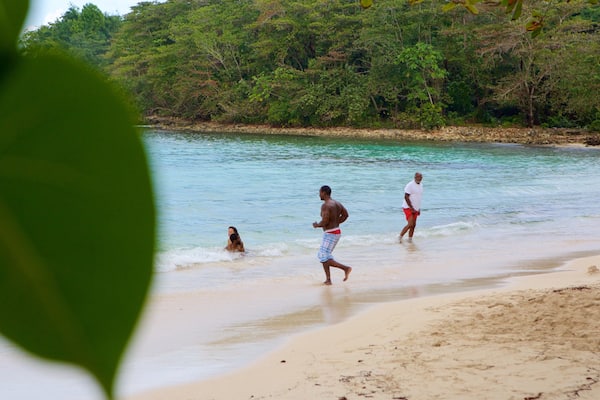 Winnifred Beach featuring a sandy beach as well as a small group of people