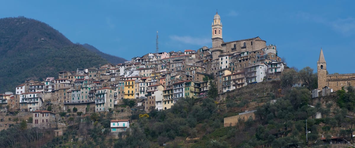 A hillside town with colorful buildings and a prominent church tower.