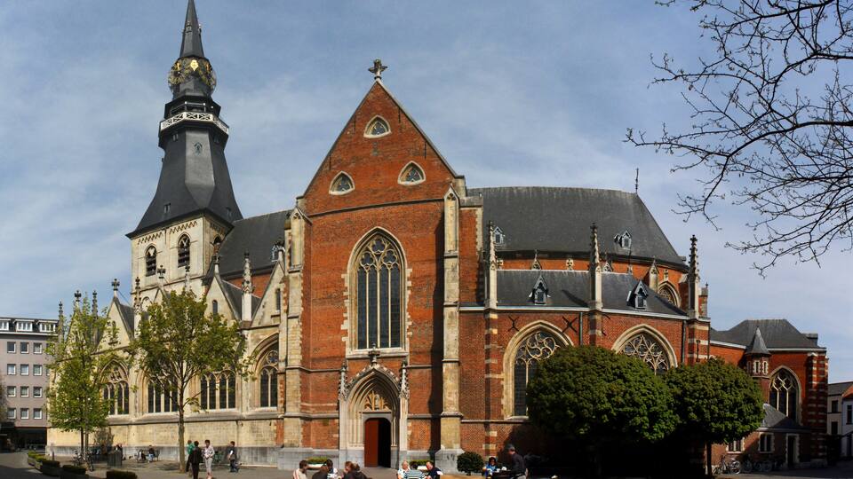A historic church with a tall spire and a large rose window.