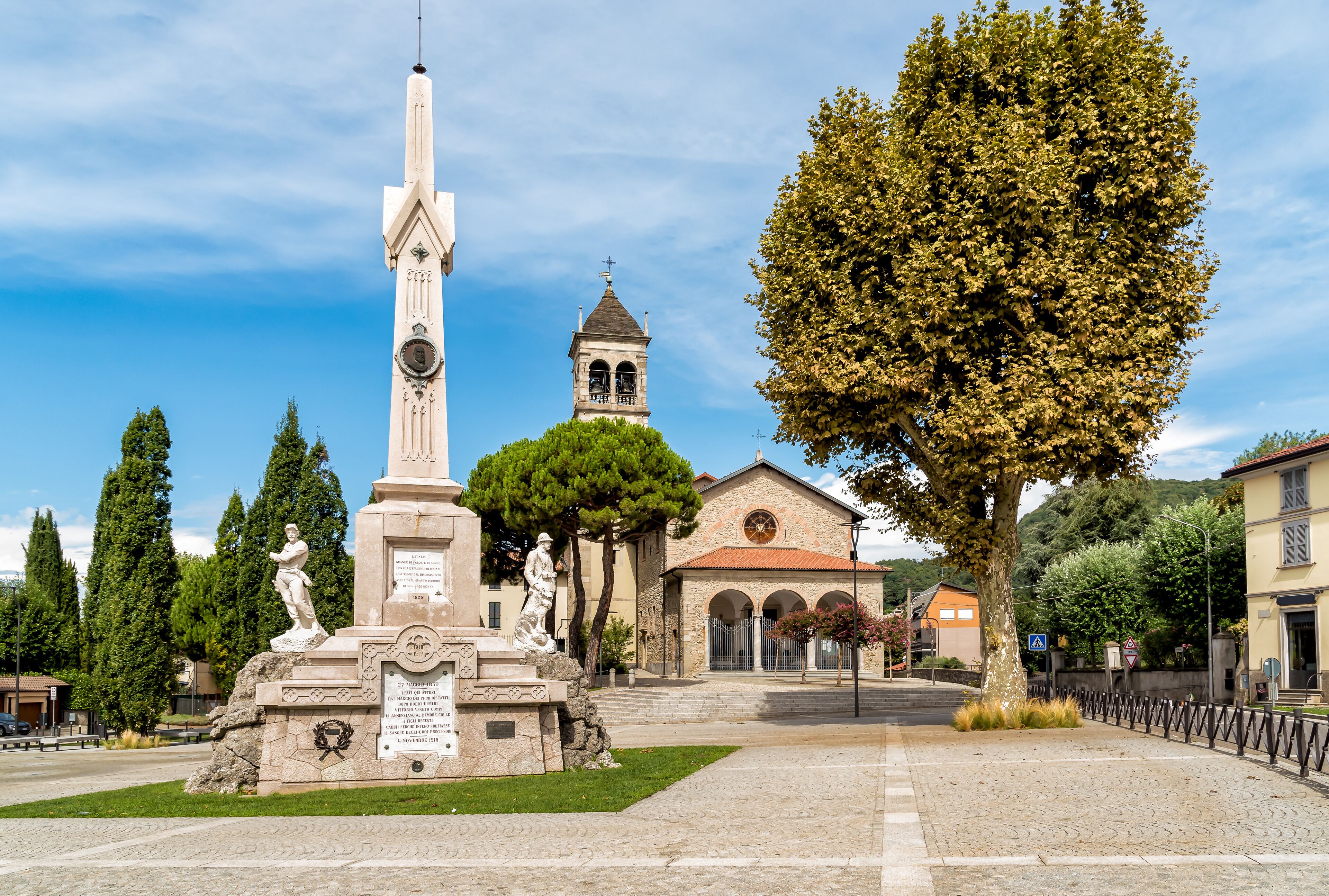 Central square with Memorial monument to the fallen and Church in the City of San Fermo della Battaglia, province of Como, Italy