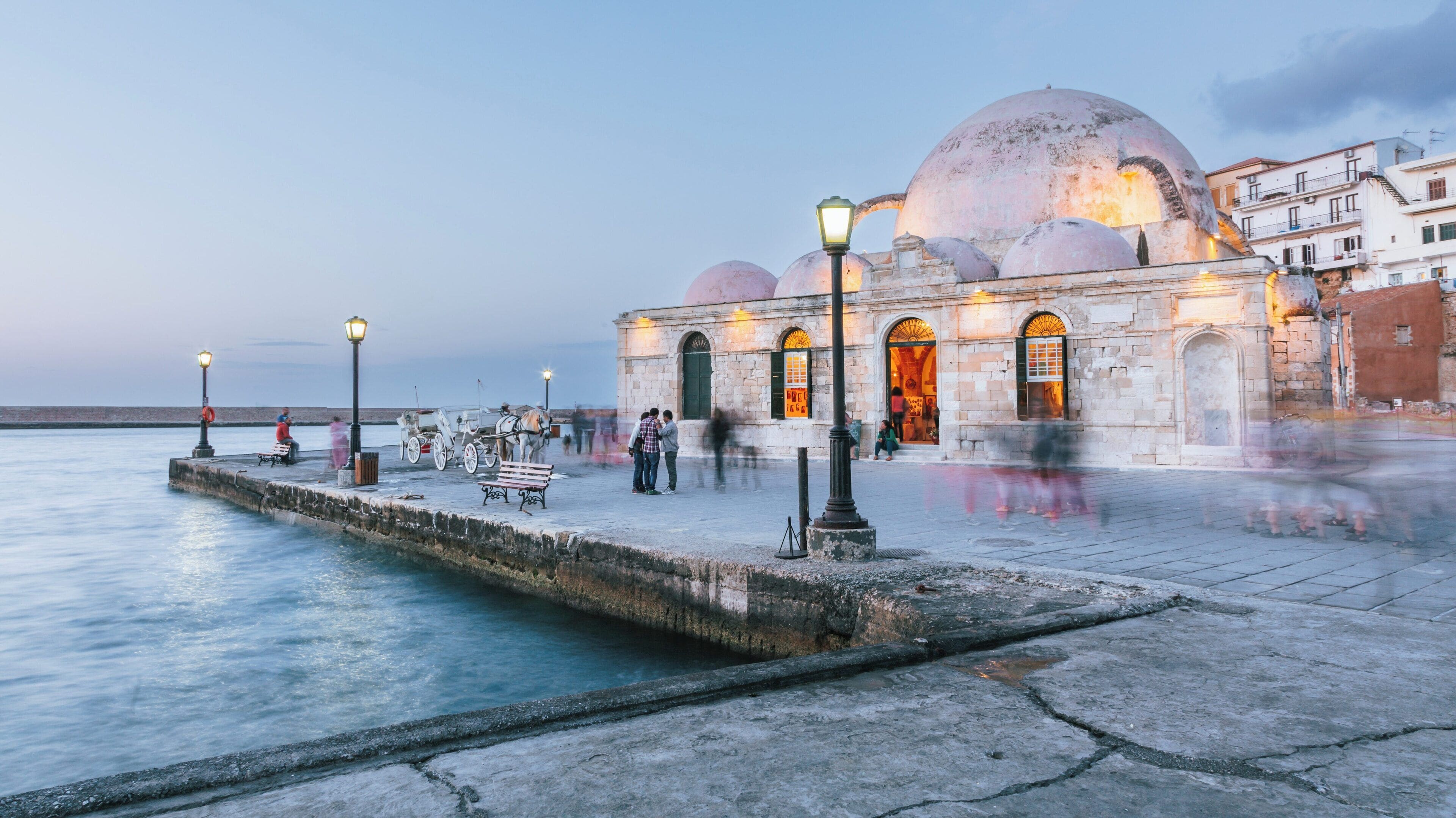 Experience the beauty of the Mosque of Kioutsouk Hassan in Chania Town, Crete at dusk near the picturesque waterfront