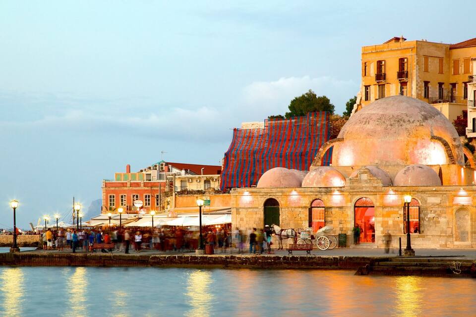 Un passeig marítim animat amb un edifici històric, una cúpula gran i vistes a l'aigua.
