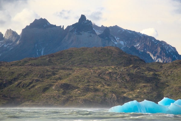 Un glacier avec des icebergs dans un fjord, entouré de montagnes.
