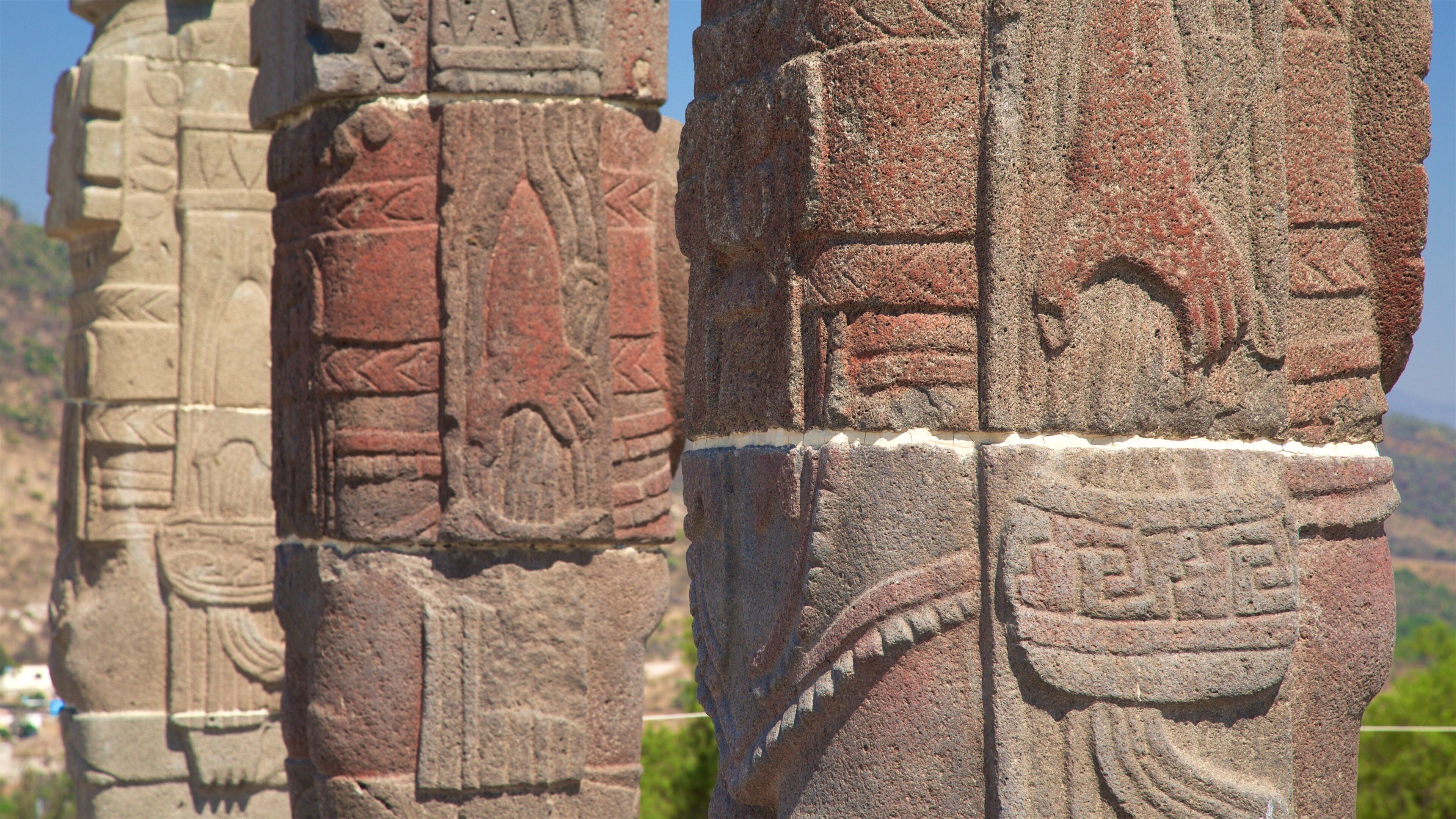 Ancient stone carvings on a column with intricate designs and patterns.