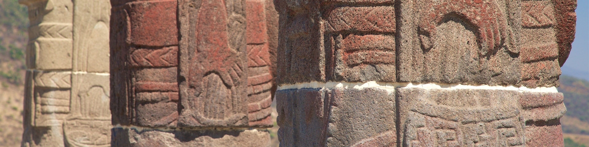 Ancient stone carvings on a column with intricate designs and patterns.