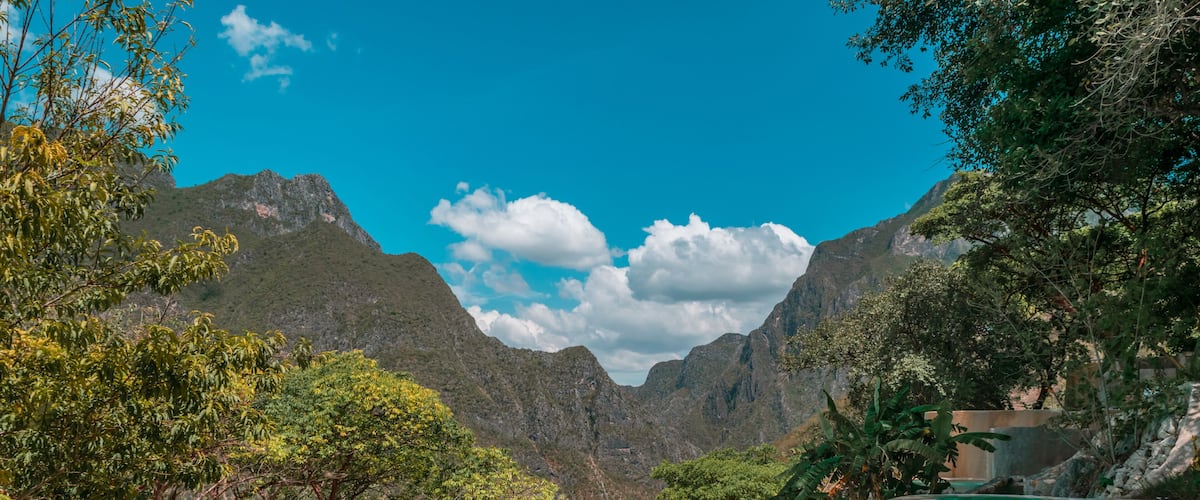 A swimming pool surrounded by lush greenery and mountains.