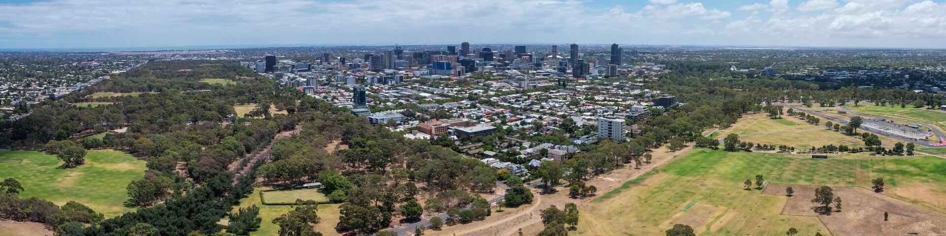 Aerial view of victoria park wetlands and sports fields with greenery and buildings, adelaide, australia.