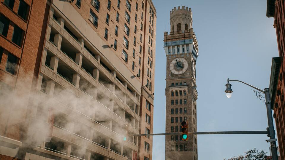 A tall brick building with a clock tower and a traffic light.