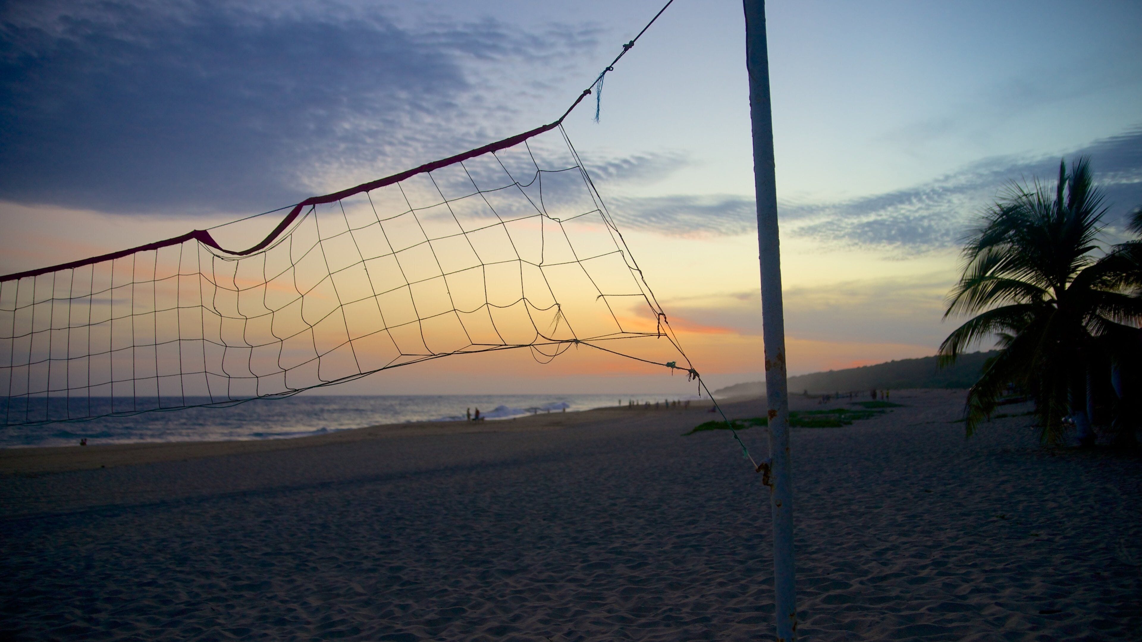 Playa Bacocho toont een zandstrand, een zonsondergang en landschappen