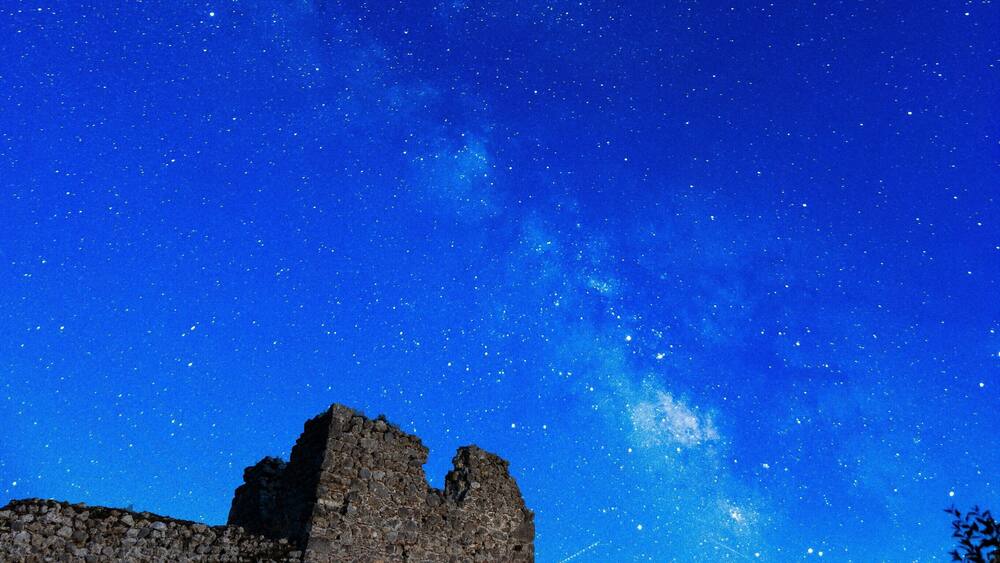 A historic stone building under a starry night sky.