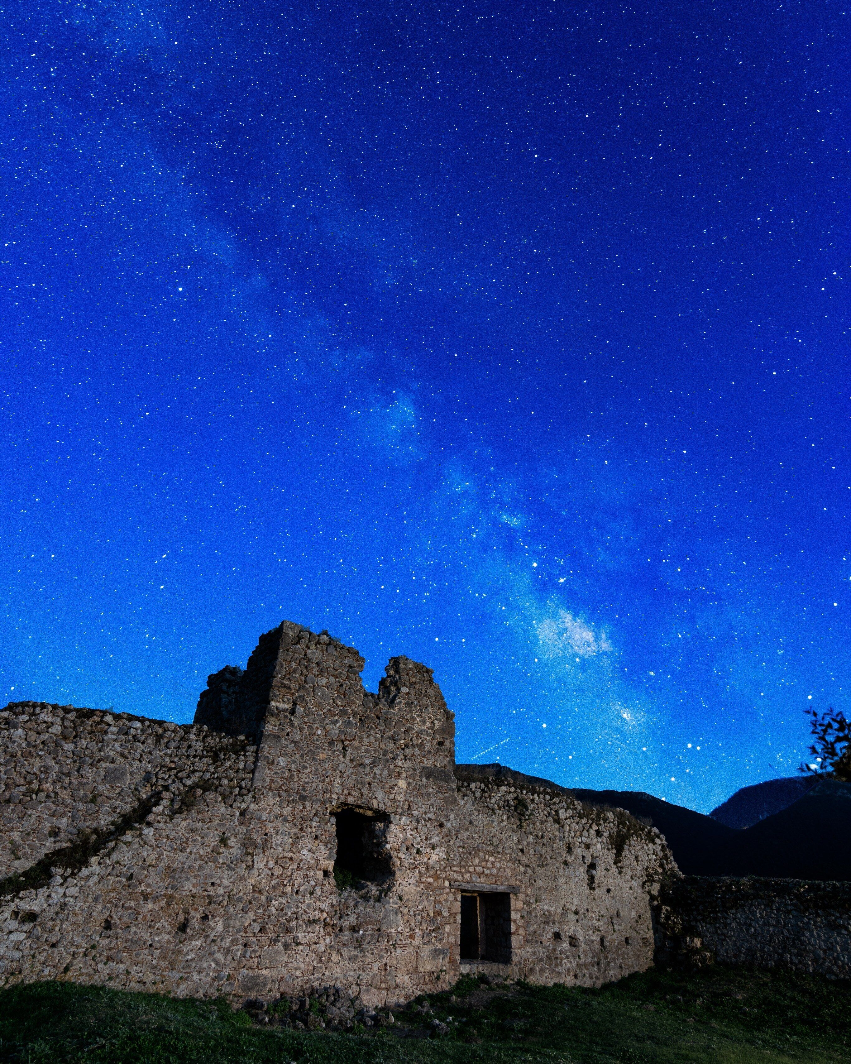 A historic stone building under a starry night sky.