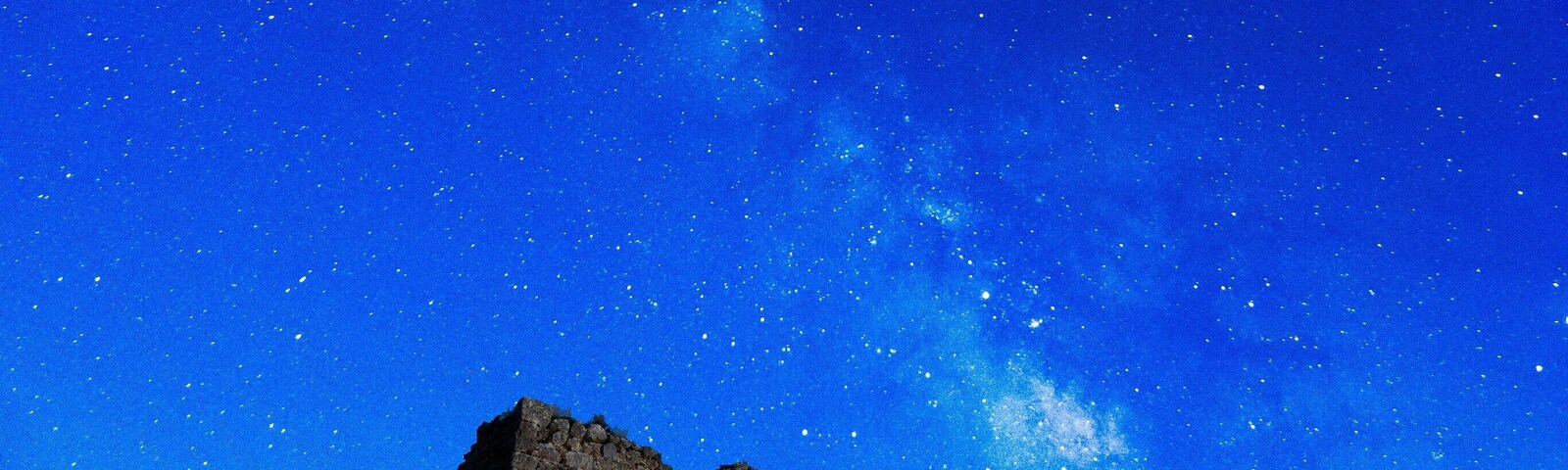 A historic stone building under a starry night sky.