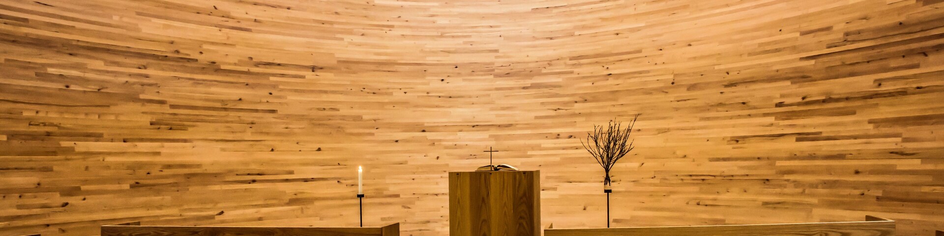 A wooden interior with benches arranged in rows.