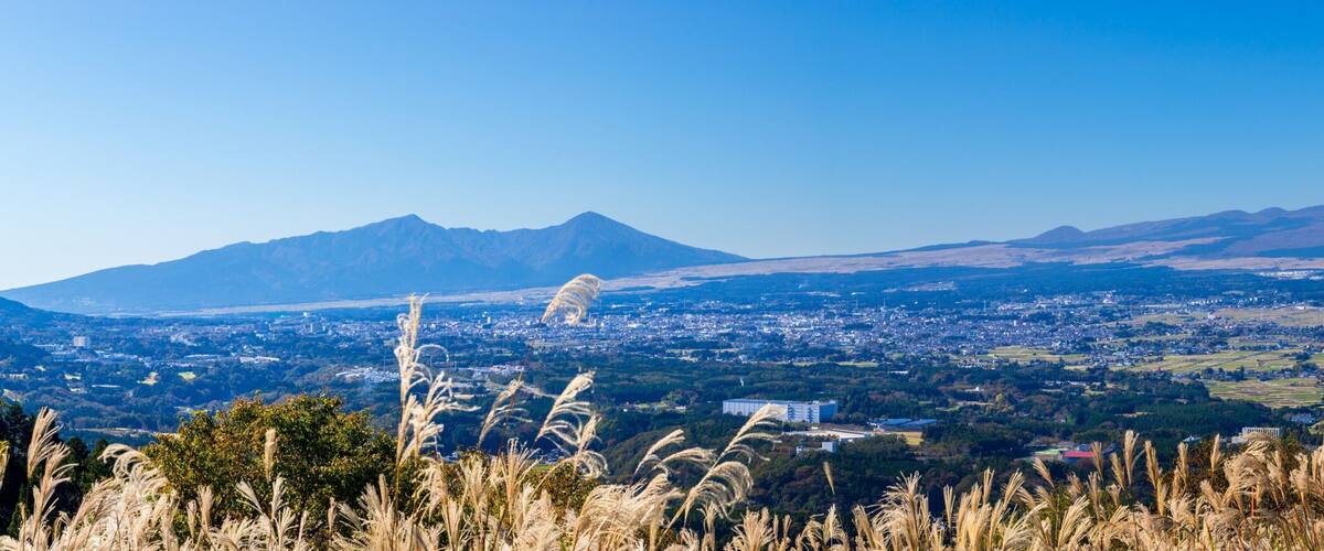 A snow-capped mountain, a town in the valley, and distant hills.