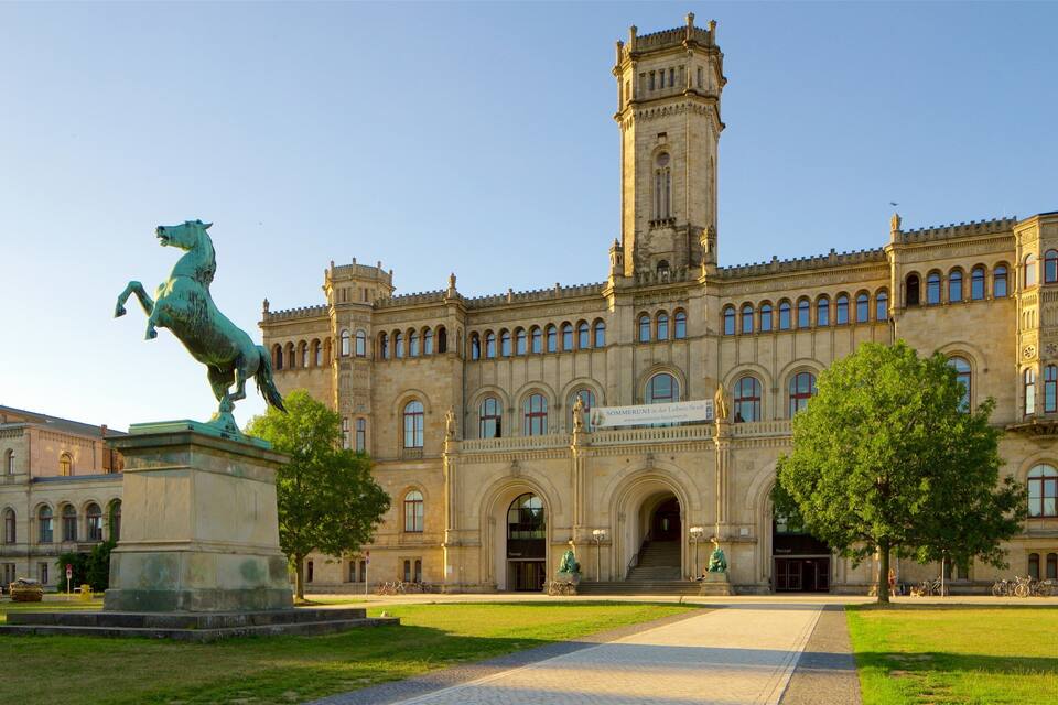 Un gran edificio histórico con una torre destacada, una estatua de un caballo y un cartel que dice "SOMMERUNT der Lebens-Stadt".