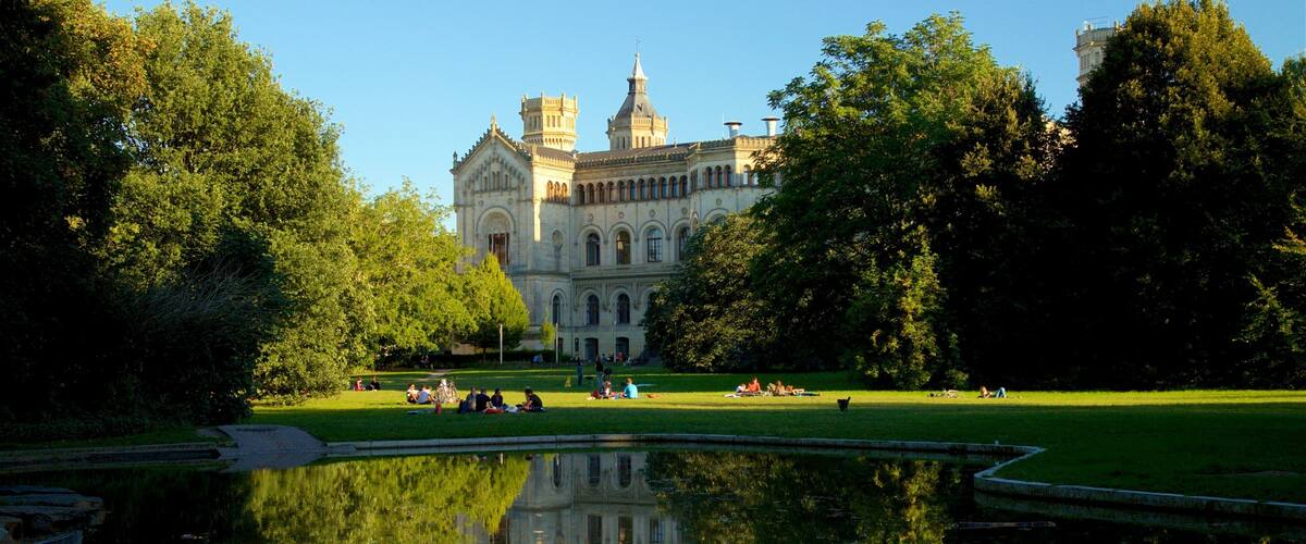 Welfenschloss das einen Park, See oder Wasserstelle und historische Architektur