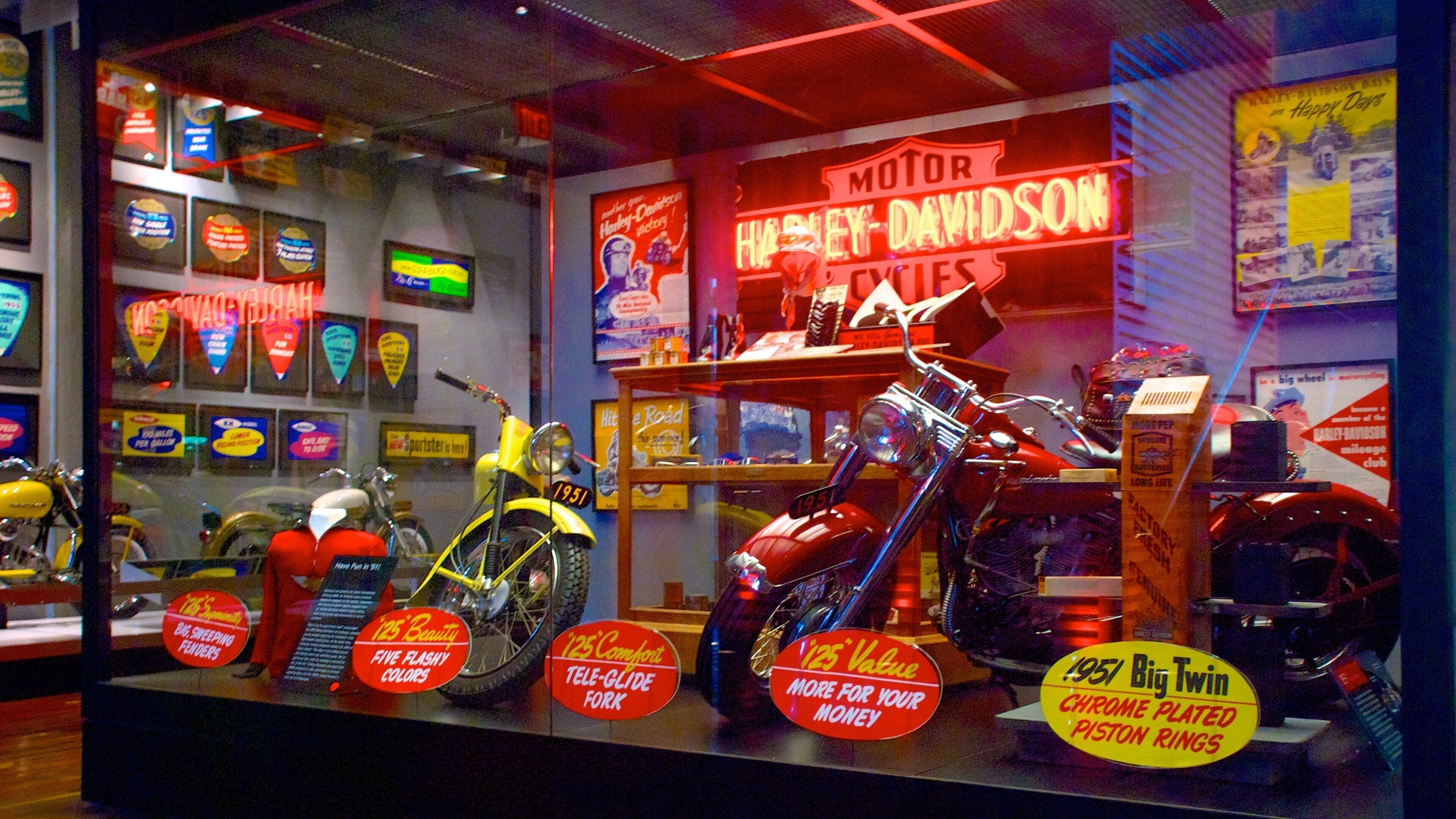 Een showroom voor motorfietsen met diverse modellen, waaronder een rode Big Twin uit 1951.