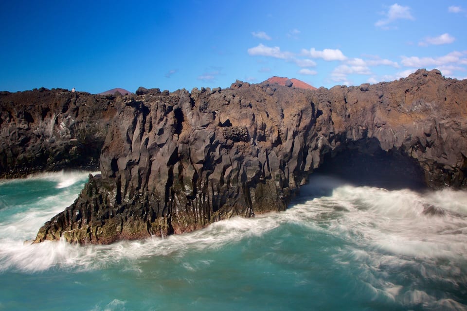 A rugged coastline with rocky cliffs and turbulent ocean waves.