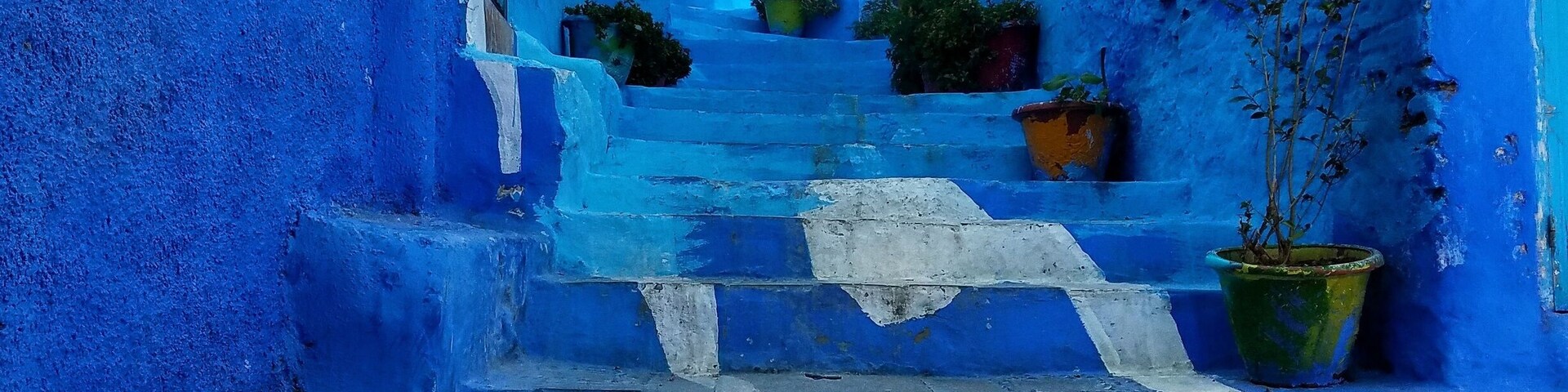 A blue-painted staircase leading up to a building with a blue door.