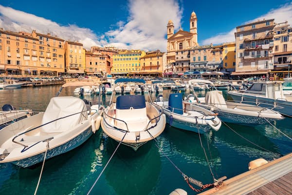 Attractive summer cityscape of Bastia port with twin-towered Church of St. Jean-Baptiste rising behind it. Splendid morning view of Corsica island, France, Europe. Beautiful Mediterranean seascape.