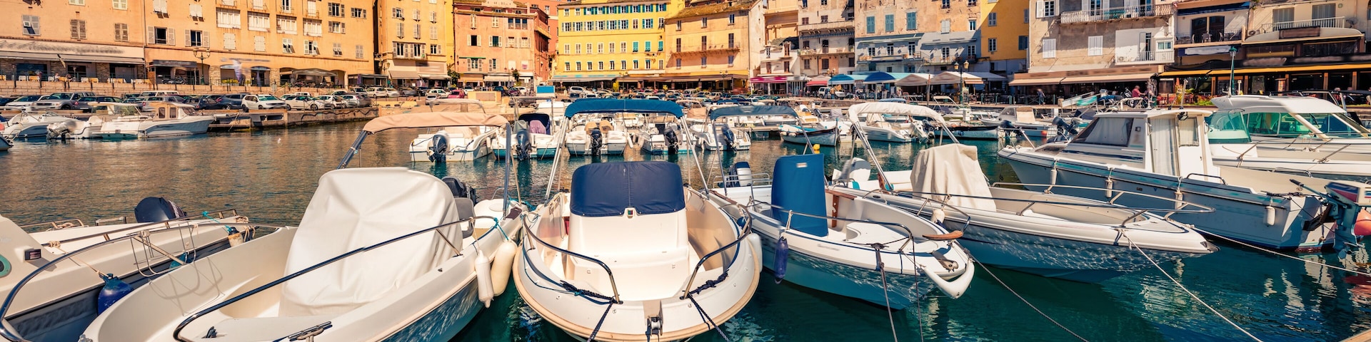 Attractive summer cityscape of Bastia port with twin-towered Church of St. Jean-Baptiste rising behind it. Splendid morning view of Corsica island, France, Europe. Beautiful Mediterranean seascape.