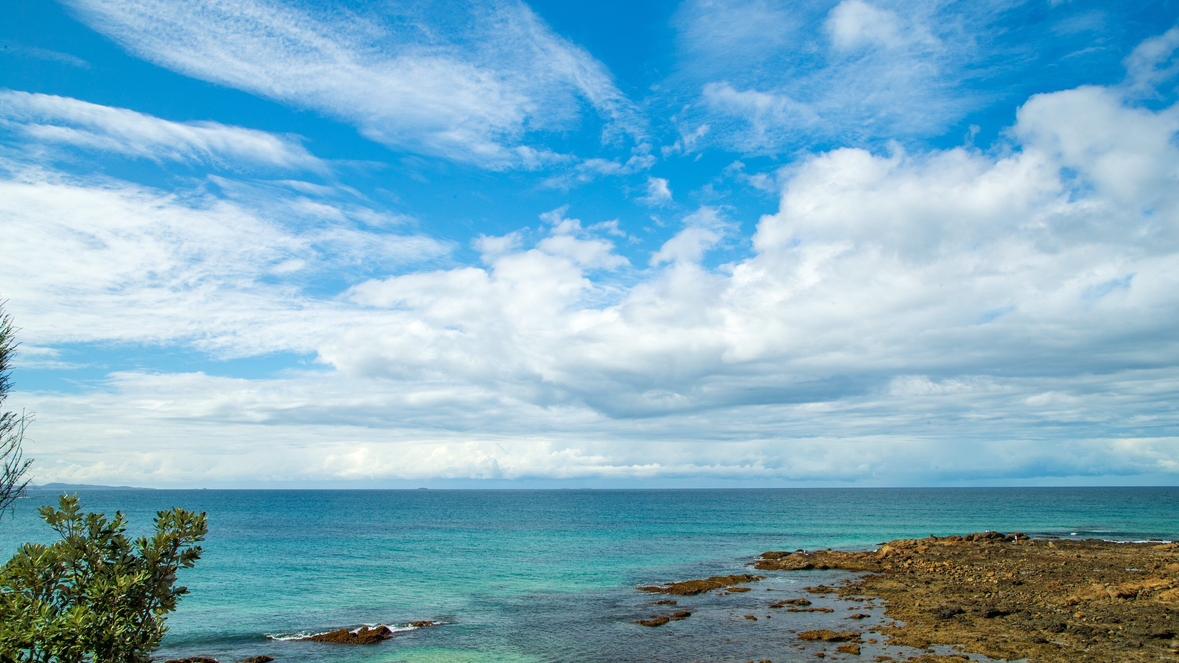 Woolgoolga Beach which includes general coastal views and rocky coastline
