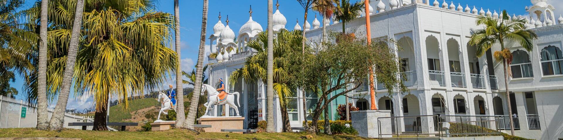 Un edificio blanco con techos abovedados y palmeras.