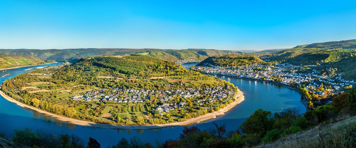 A river curving through a town surrounded by hills.