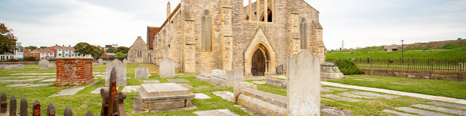 A historic church with a large arched entrance and a tall bell tower.